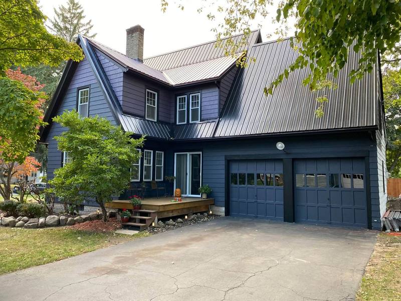 Dark blue two-story house with a double garage, freshly painted exterior