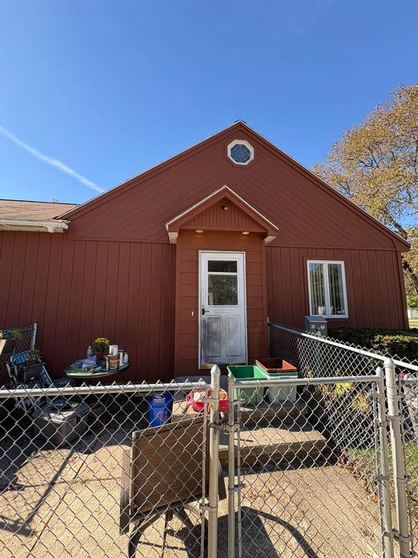 Red house front with a white entry door, freshly painted