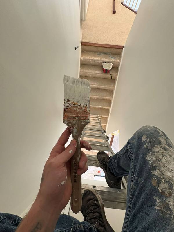 Freshly painted stairwell with a paint brush in hand